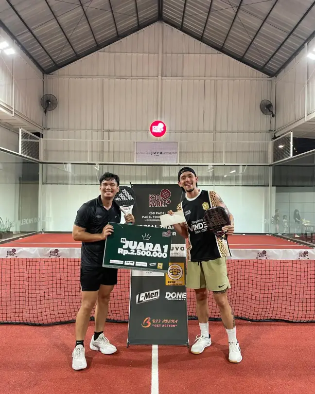Tournament winners holding their prize board on court